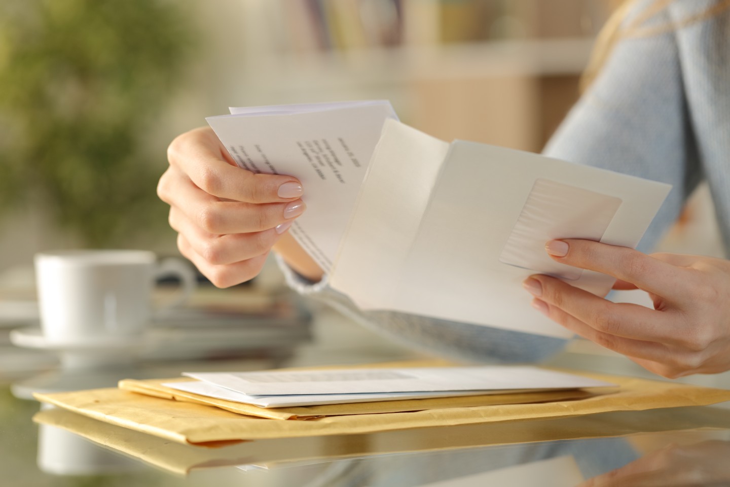 Personne ouvrant une enveloppe sur une table